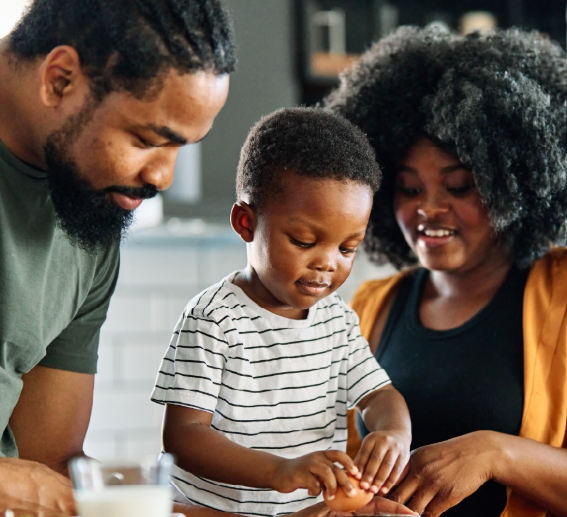A Black couple playing with their child.